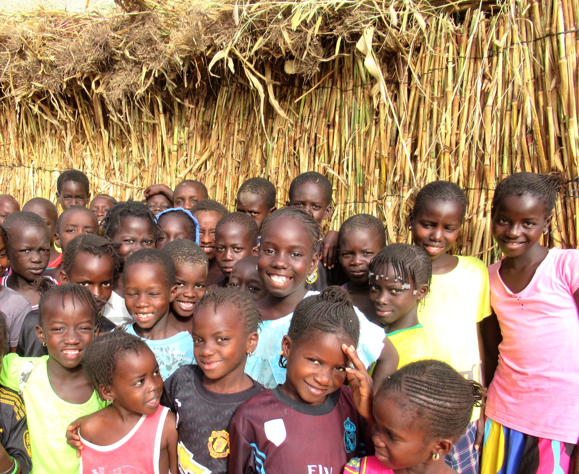 Impact Beyond Recruitment 4 Students gathered outside their temporary grass classroom before the permanent Senegal school was built