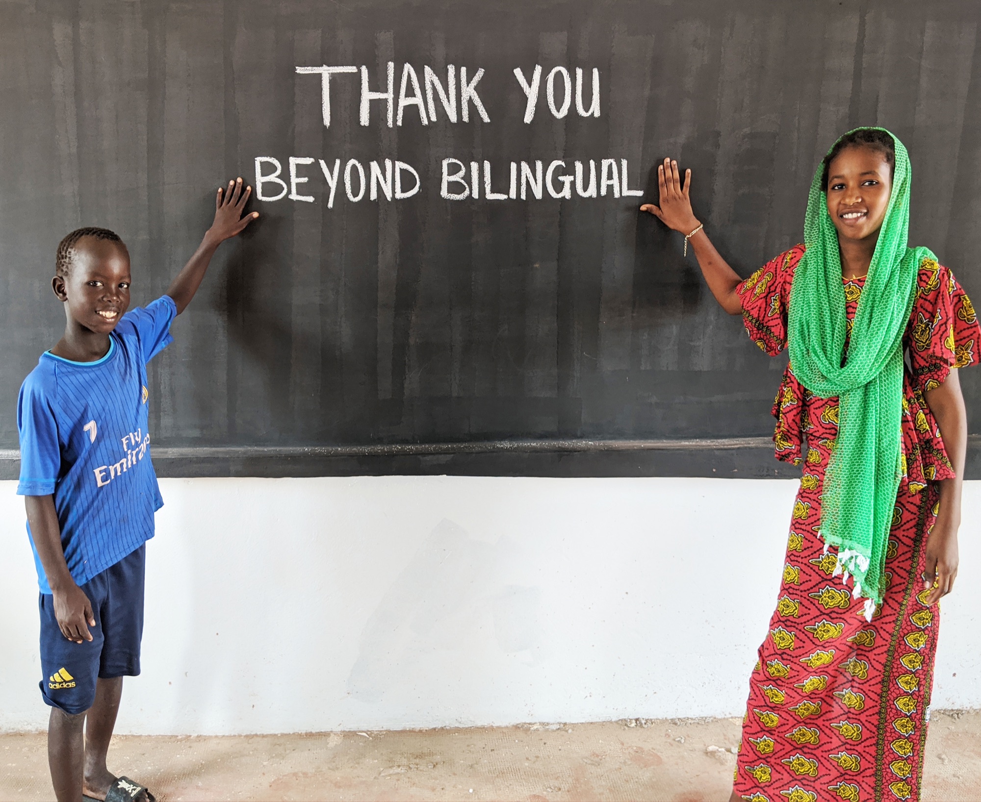 Students beside a thank-you message for Beyond Bilingual at the Senegal school